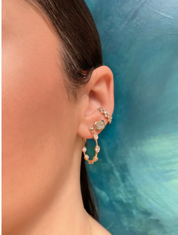 a woman wearing diamond hoop earrings.